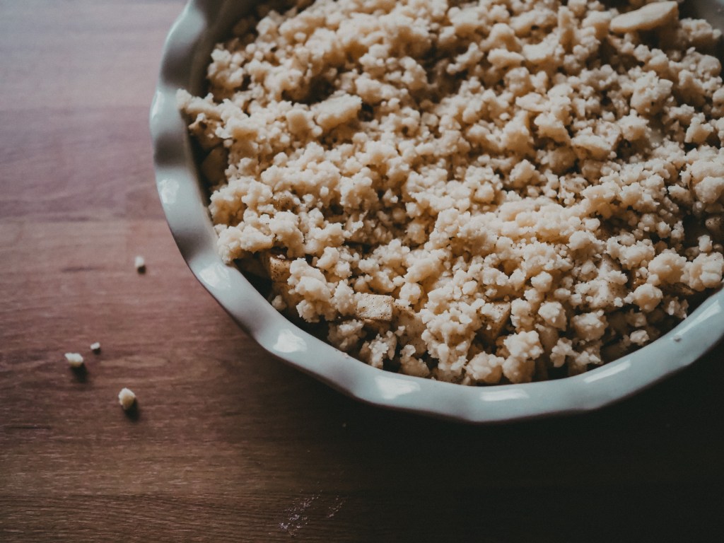 Streusel auf die Äpfel geben 